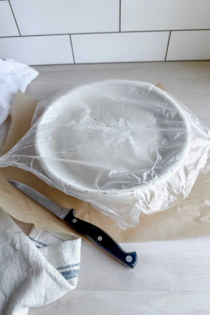 plastic wrap covered loaf of gluten free sourdough bread