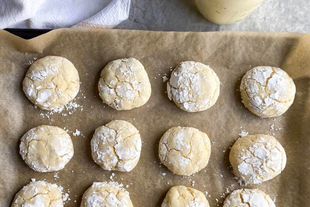 cookie sheet with parchment paper and gluten free gooey butter cookies on top of it