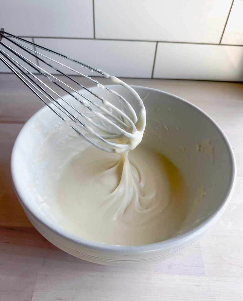 a whisk mixing until frosting is smooth and clump free