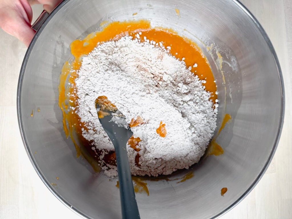 large metal mixing bowl with wet and dry ingredients
