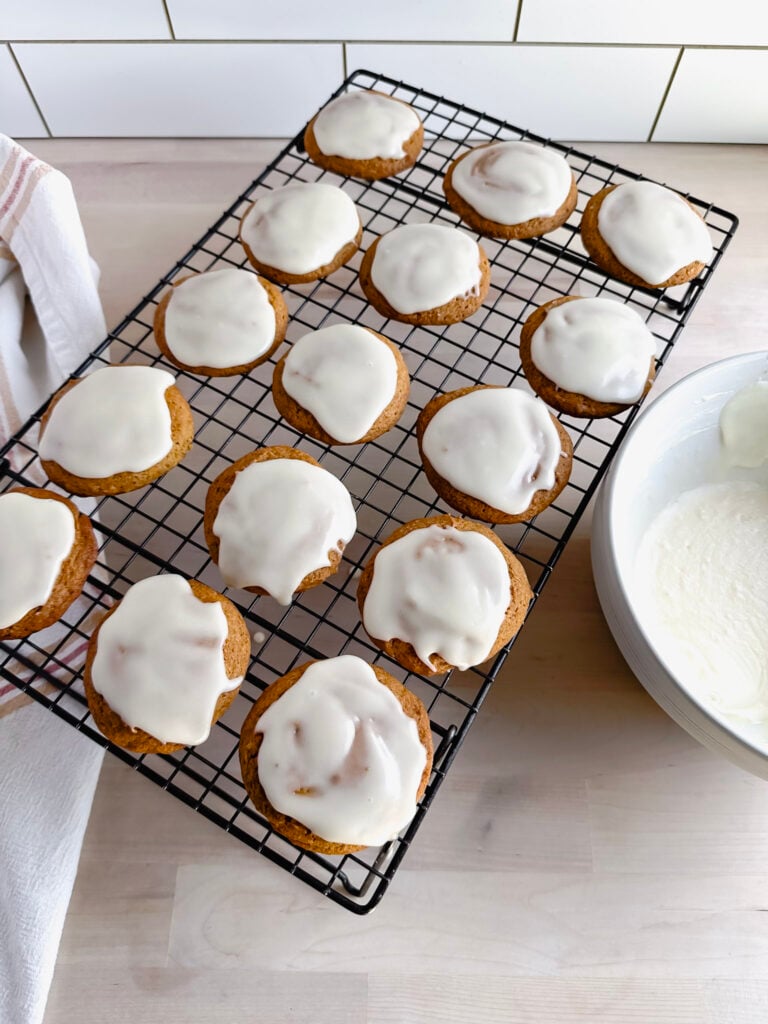 cooling rack with pumpkin cookies frosted