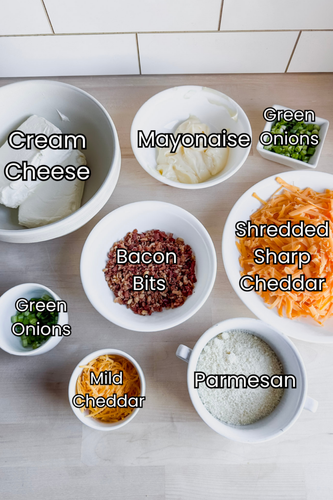 bowls on a counter with cheese ball ingredients including cream cheese, sharp cheddar, Parmesan and green onions