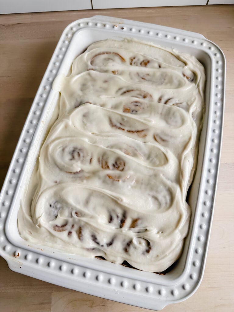 white baking dish with frosted gf cinnamon rolls