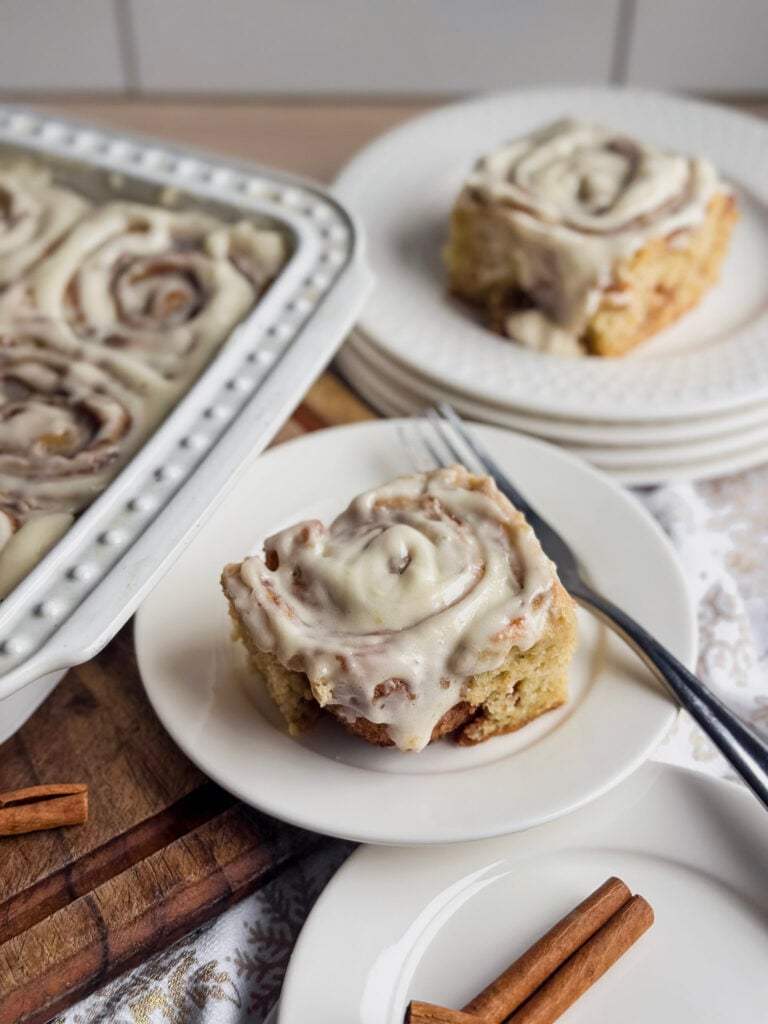 white plates with gluten free sourdough cinnamon rolls with a fork near by