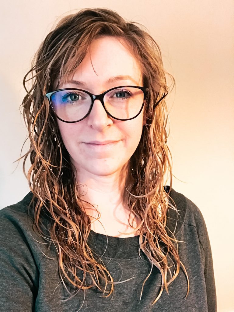 Woman in gray shirt with curly air dried hair and hair gel
