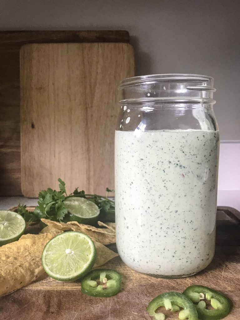 lime wedges jalepenos and cilantro sauce sitting on top of a cutting board