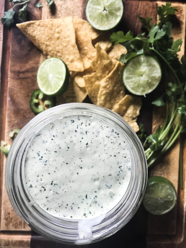 creamy cilantro sauce dressing on cutting board with chips
