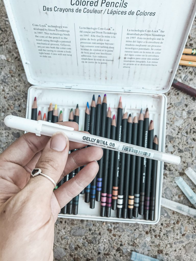 white gel pen overhead shot above colored pencils