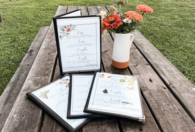 homeschool morning time menus laid on a picnic table with a vase of flowers