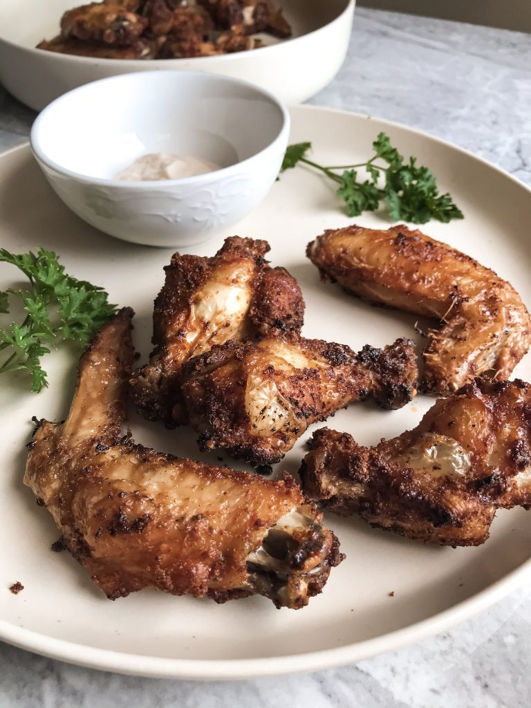 chicken wings cooked in the air fryer sitting on plate with parsley
