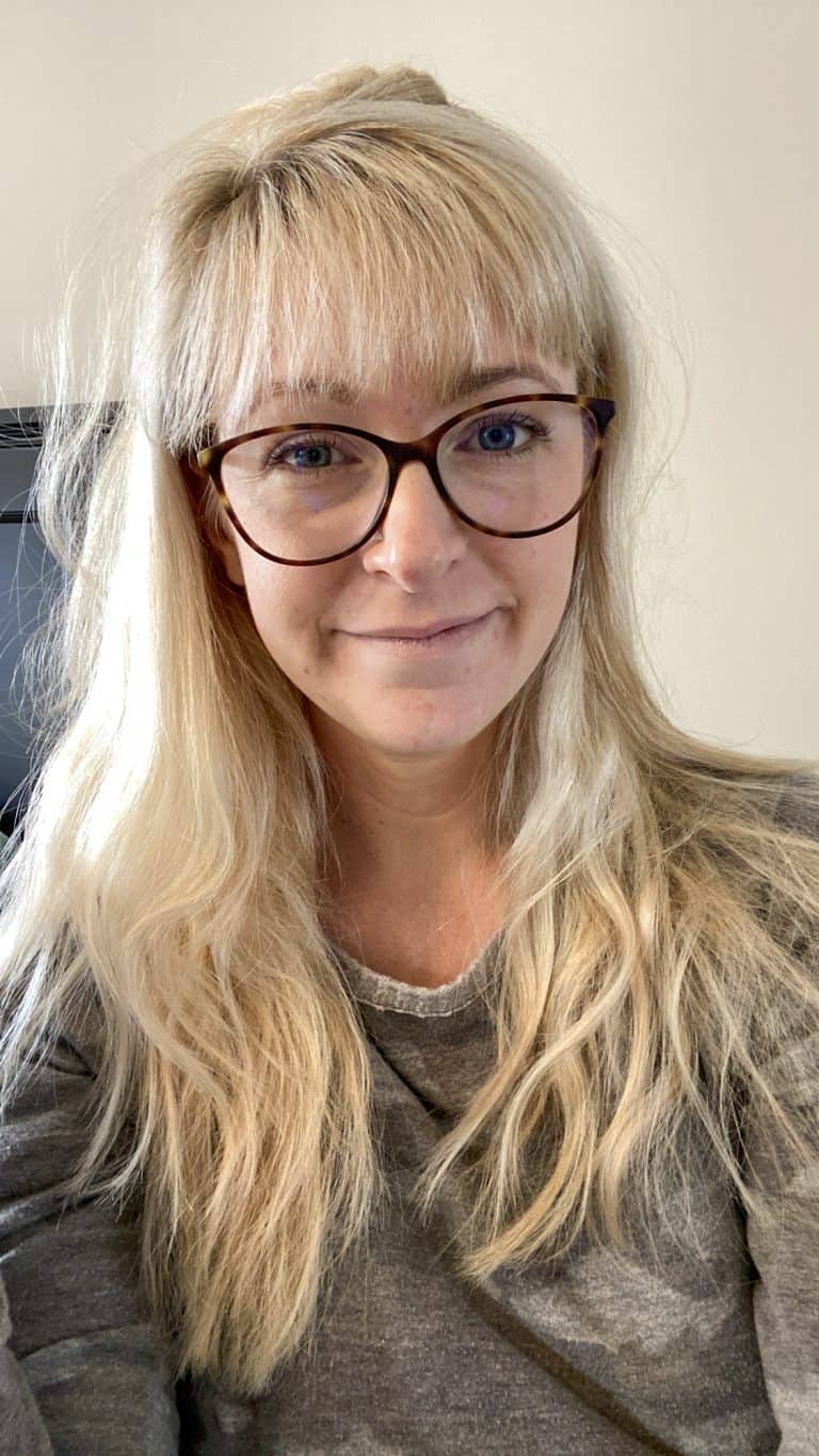 photo of Joanna Overly with glasses on and blonde hair down. Wearing a camo shirt in this article about her favorite things.