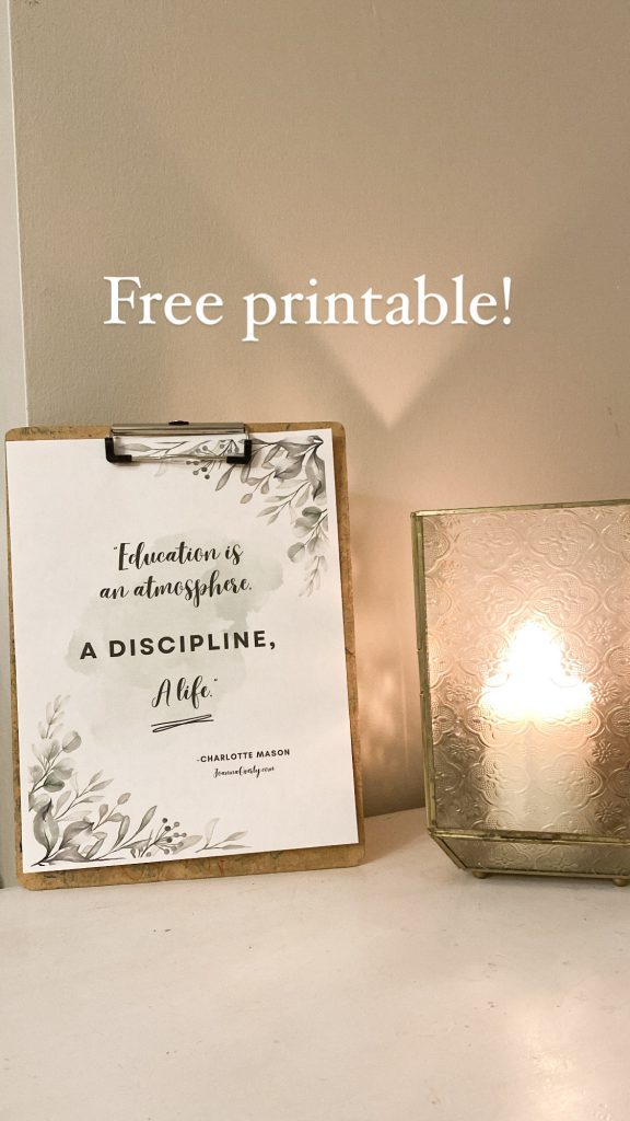 printable on table near candle saying education is an atmosphere, a discipline, a life which helps us focus when homeschooling multiple ages
