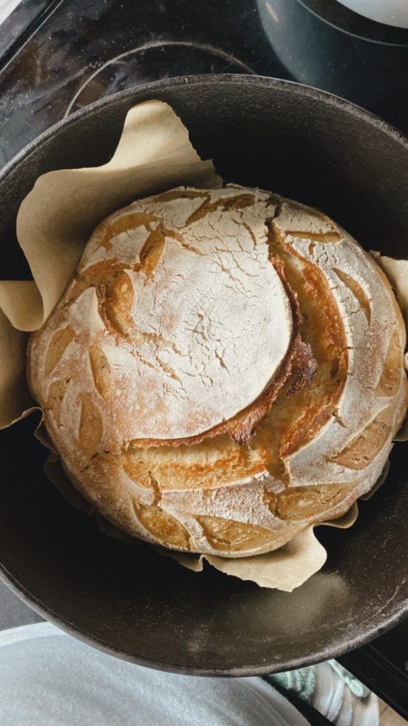favorite thing my dutch oven by lodge cast iron with a round loaf of sourdough bread inside, 