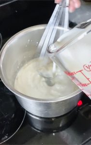 pouring milk into the sauce mixture