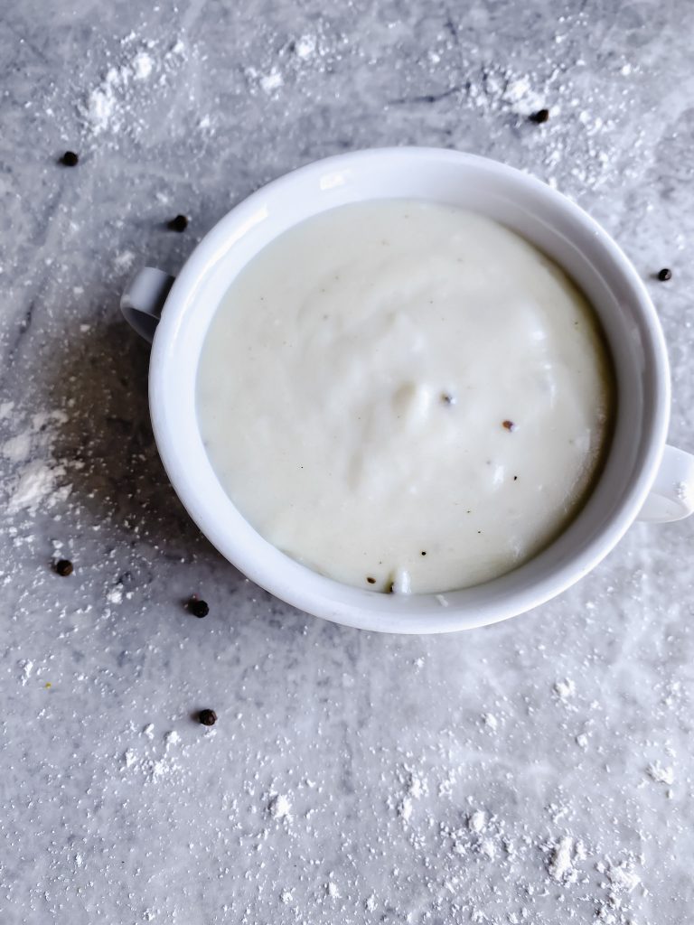 bowl of bechamel sauce on gray counter top