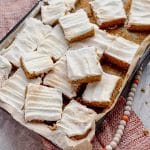 a sheet pan with gluten free pumpkin bars with cream cheese frosting arranged on a pan