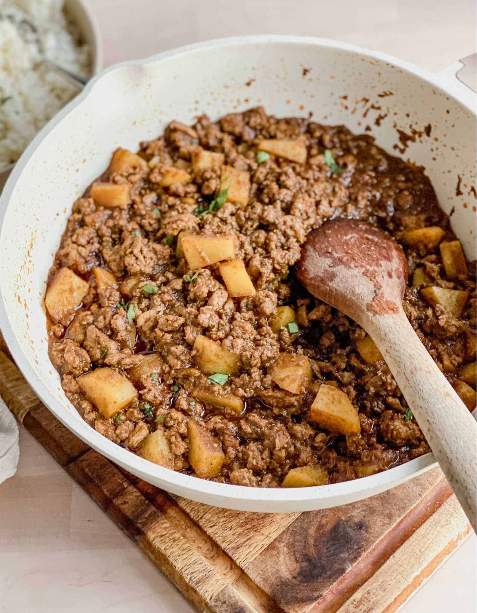 large skillet with ground meat and potatoes for Picadillo
