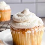 vegan cream cheese frosting on top of a cupcake on a white plate