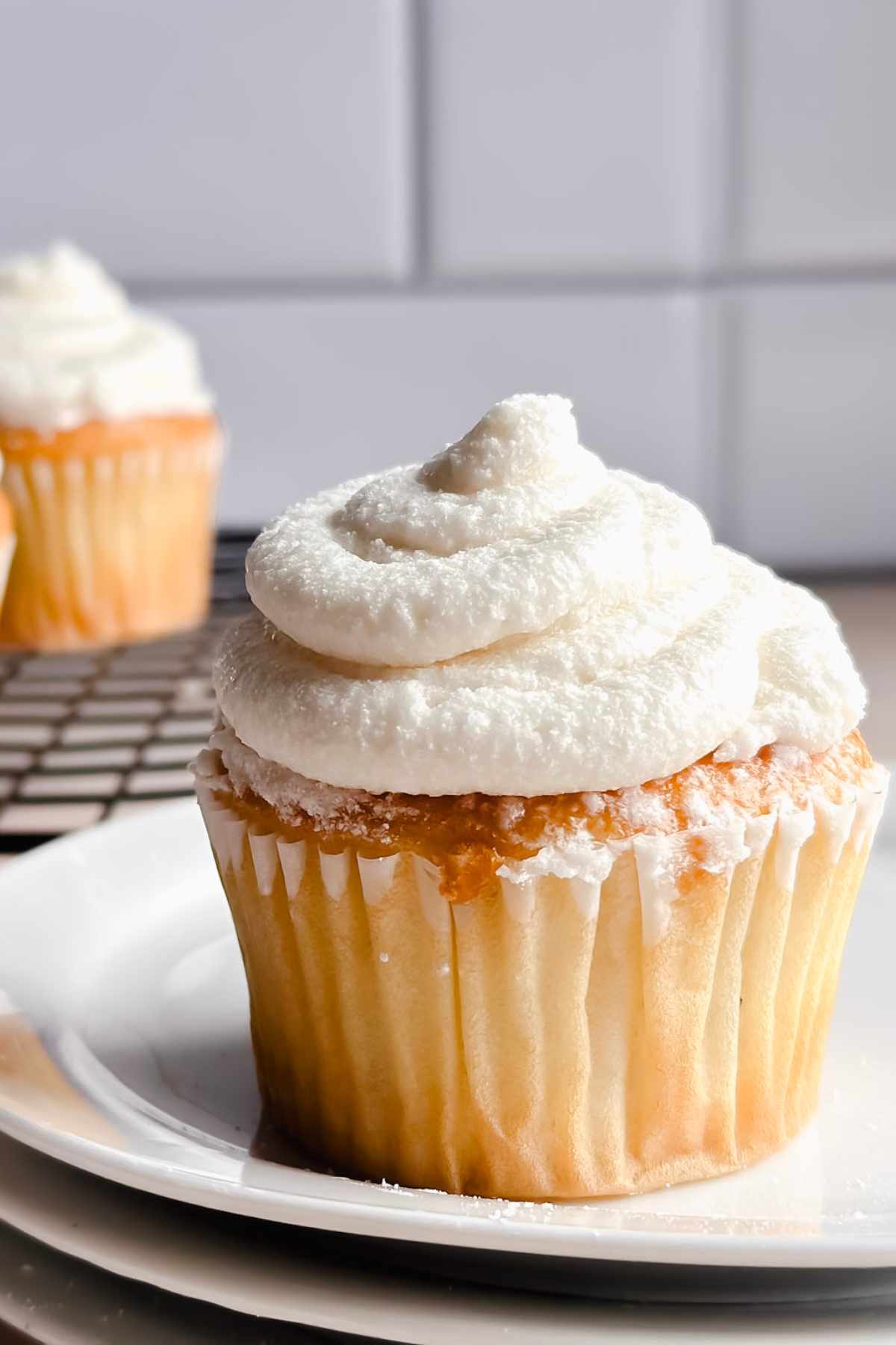 vegan cream cheese frosting on top of a cupcake on a white plate