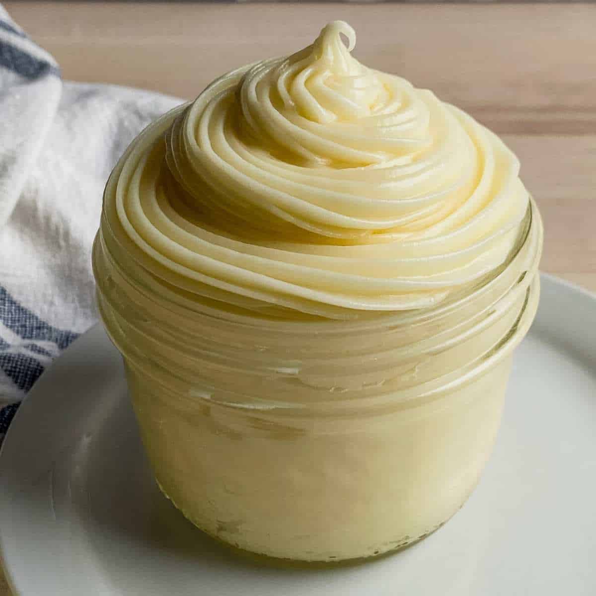 close up shot of cream cheese frosting piped into a cup