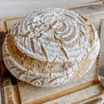 loaf of gluten free sourdough round boule on cutting board
