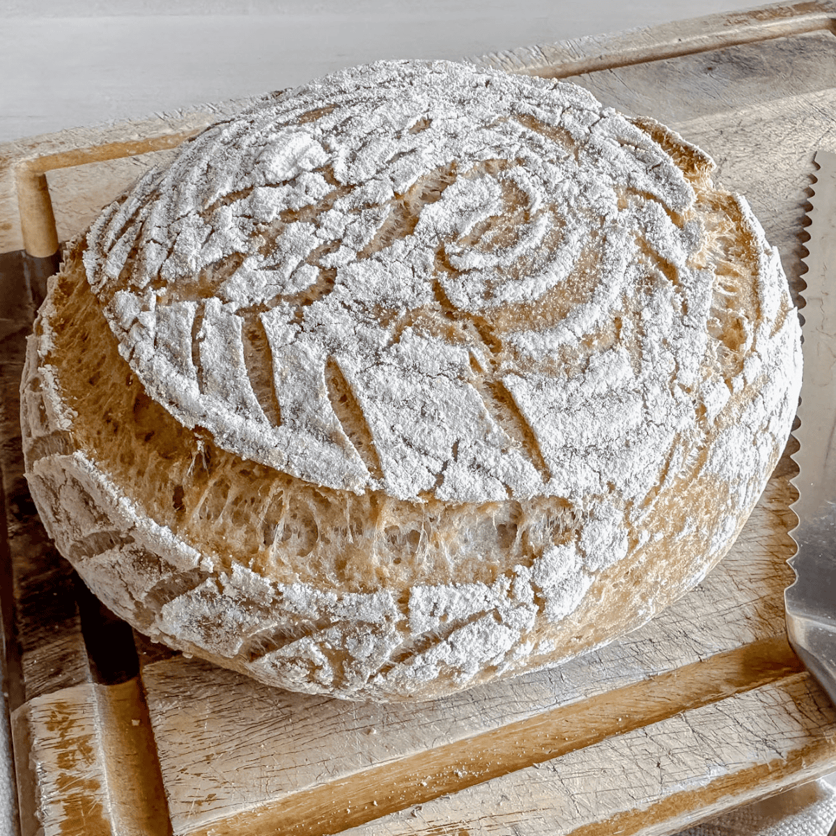 loaf of gluten free sourdough round boule on cutting board
