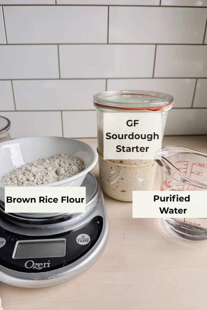 food scale with bowl of brown rice flour on it with gluten free sourdough starter in a jar