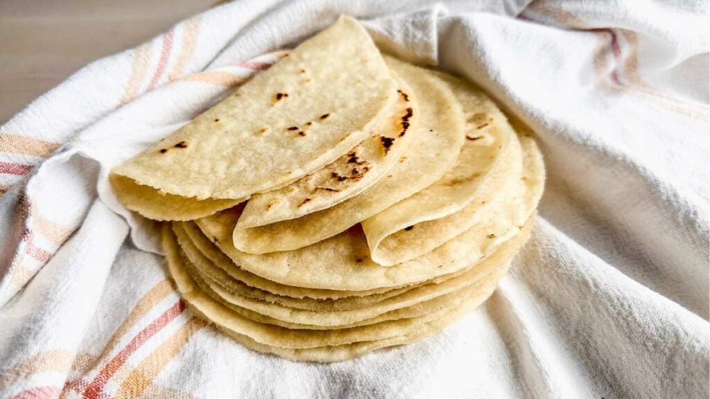 pile of flexible gluten free tortillas on a tea towel