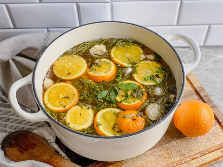 sauce pan with lemons, oranges and herbs floating in brine water