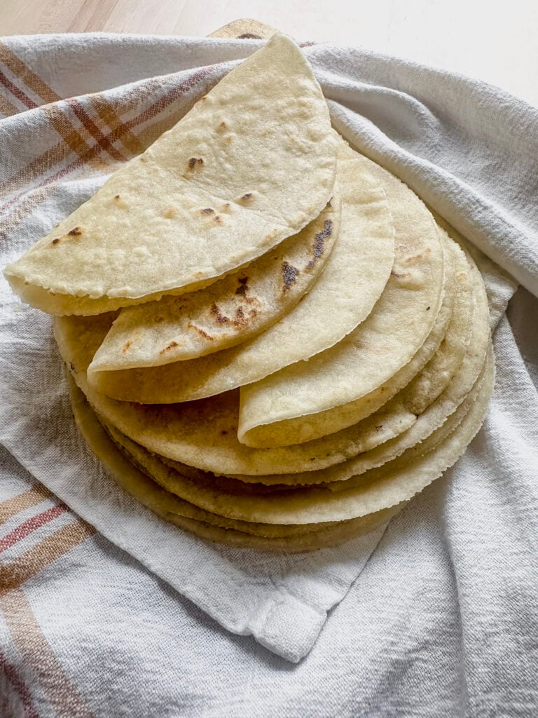 stack of gluten free tortillas on a white tea towel