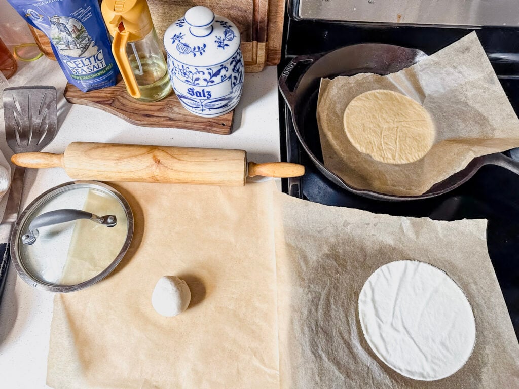 kitchen set up with tortillas being rolled out and cooked on the work station