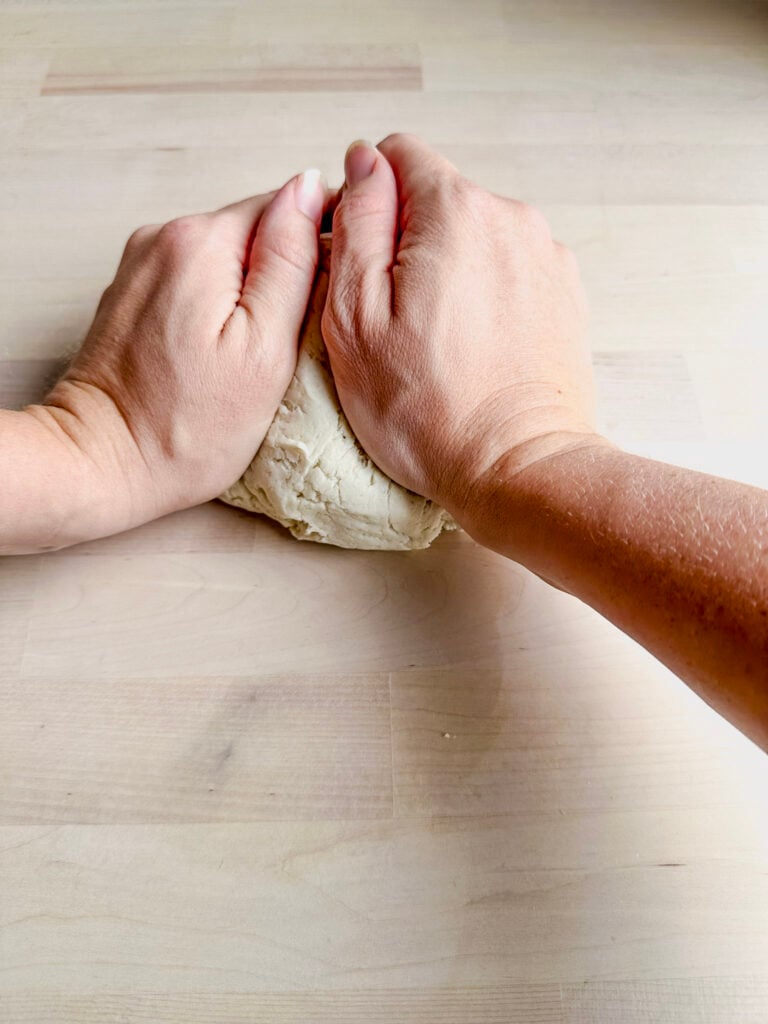two hands kneading tortilla doug