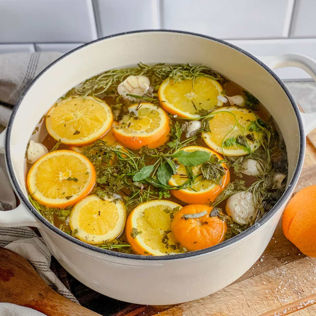 white stock pot with brine ingredients floating in water
