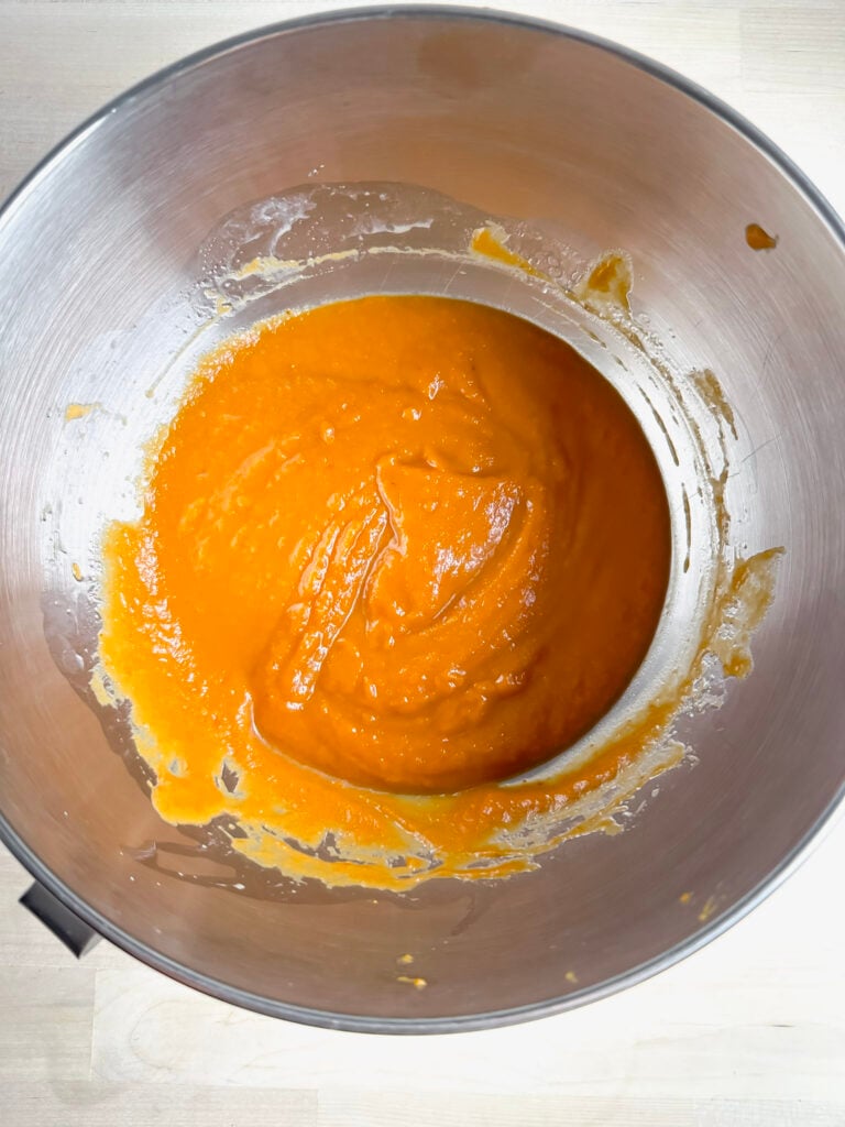 large metal mixing bowl with wet ingredients all mixed till combined