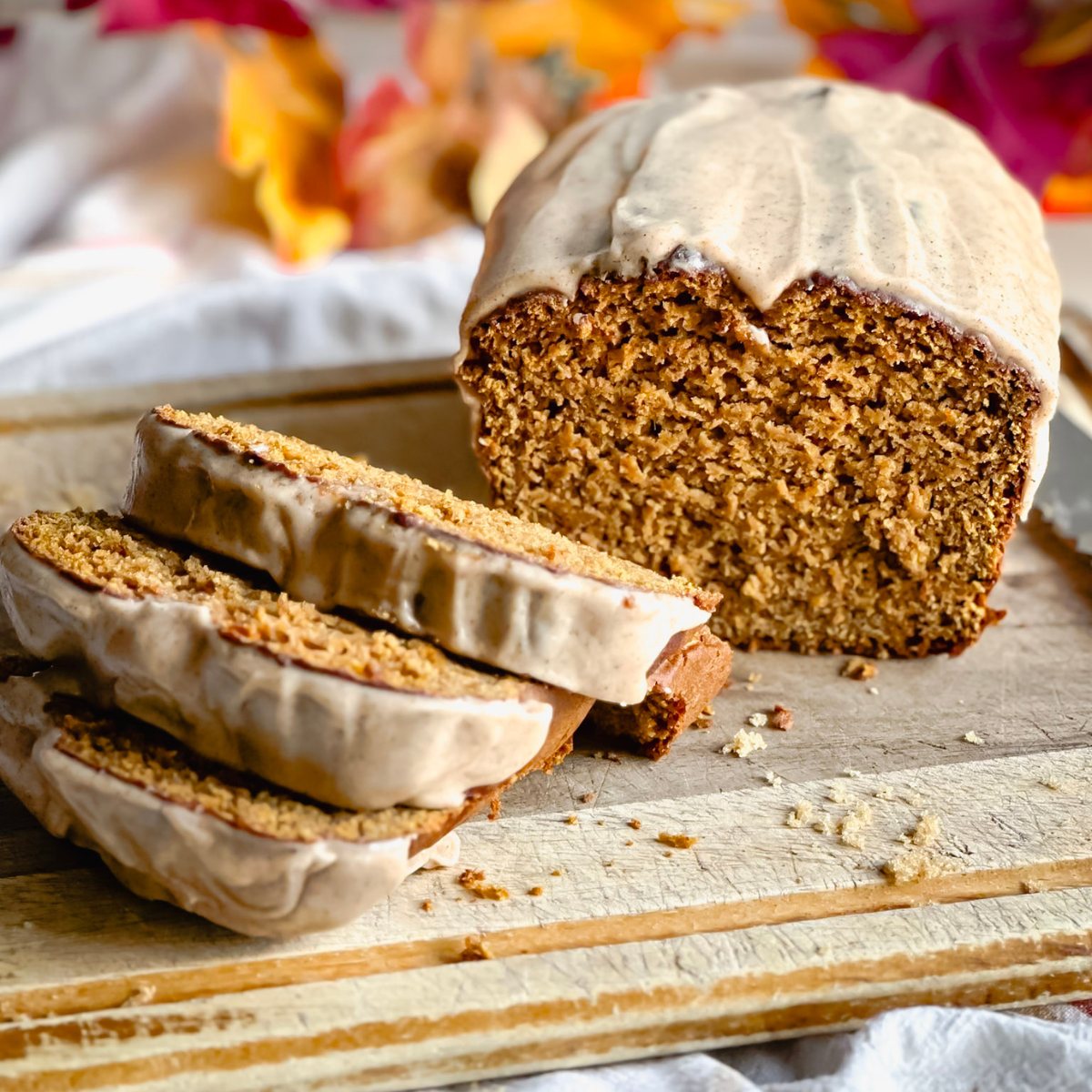 partially sliced loaf of gluten free pumpkin bread on a wooden cutting board