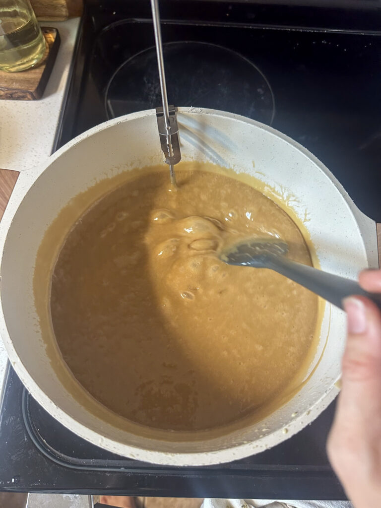 caramel sauce ingredients in a white sauce pan starting to simmer