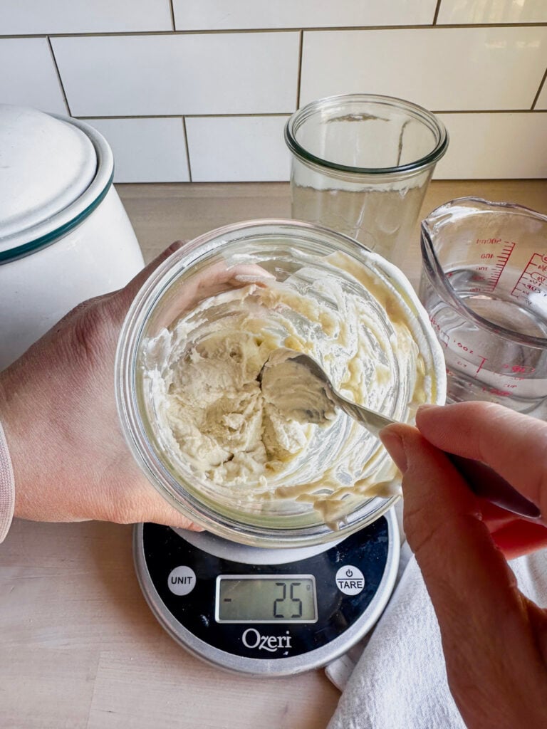 jar of starter showing texture being a little lumpy and thick yet
