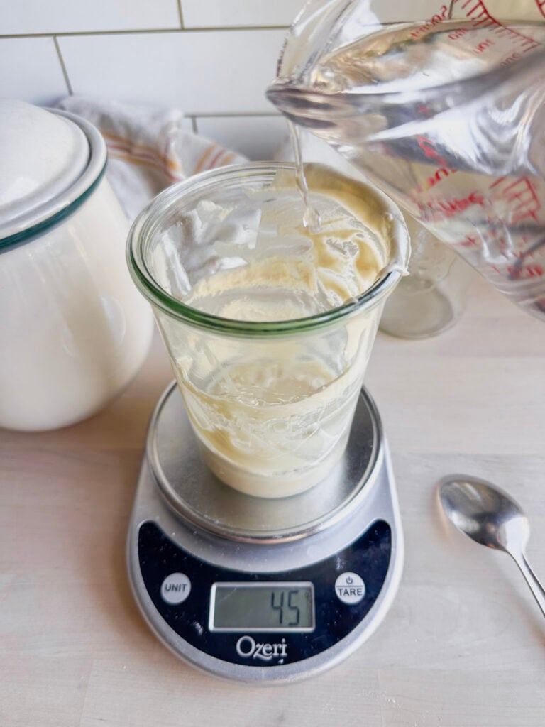 adding 50 grams water to the starter on the kitchen scale