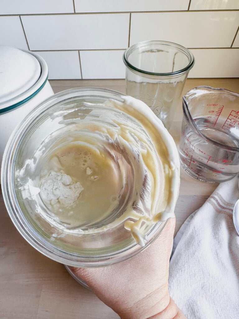 jar showing starter, brown rice flour and water added to it.